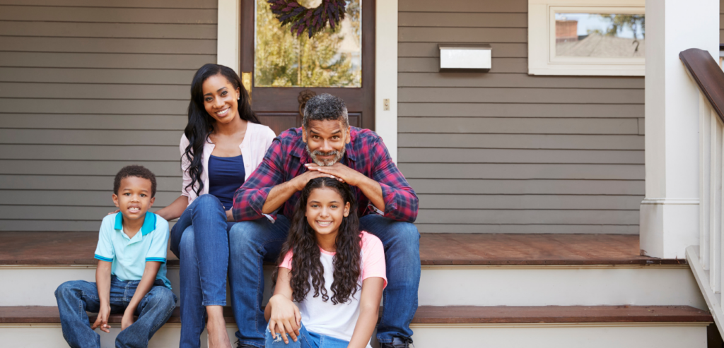 African American family sitting on the front steps of house
