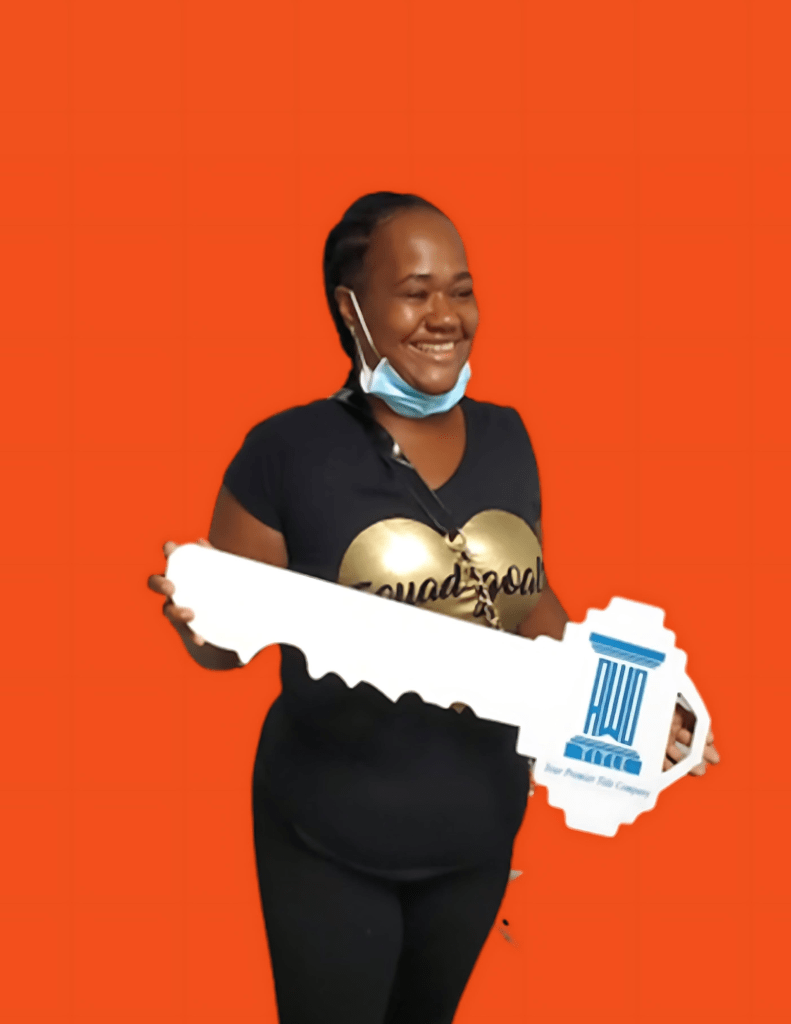 Sharron holding a sold sign