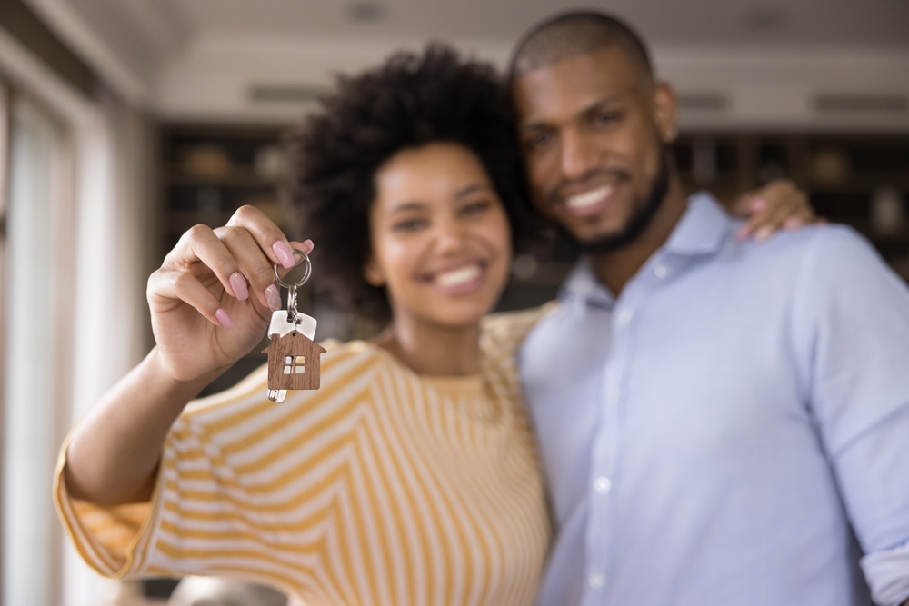 Couple holding keys to a house