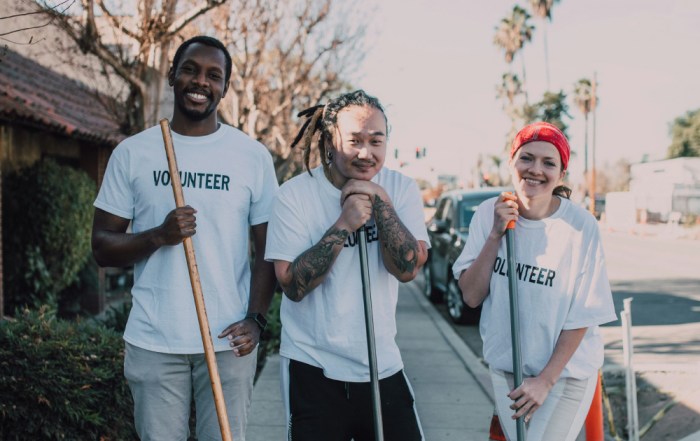 Three volunteers with gardening tools